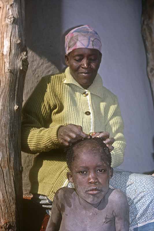 Shaving the head of her son, Serowe