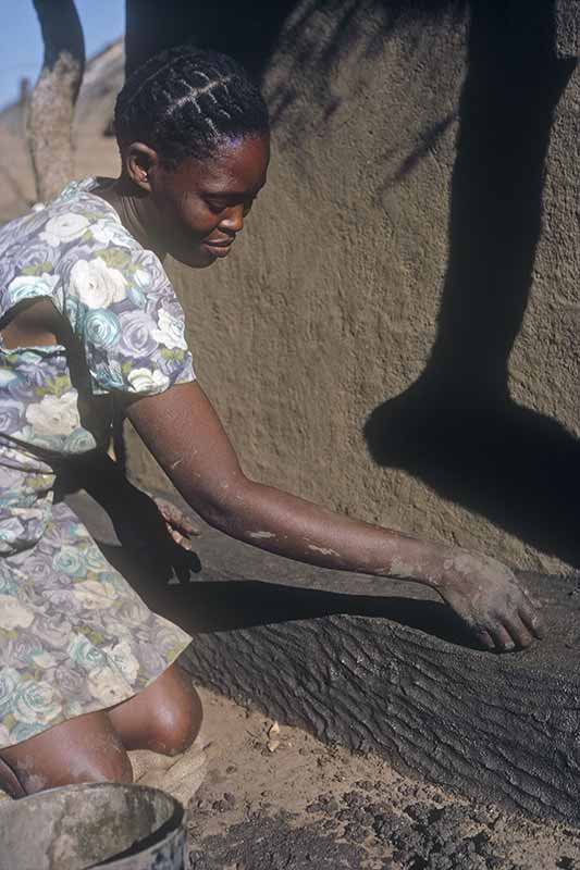 Girl plastering a house, Naledi