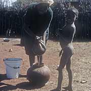 Woman preparing maize beer, Kanye