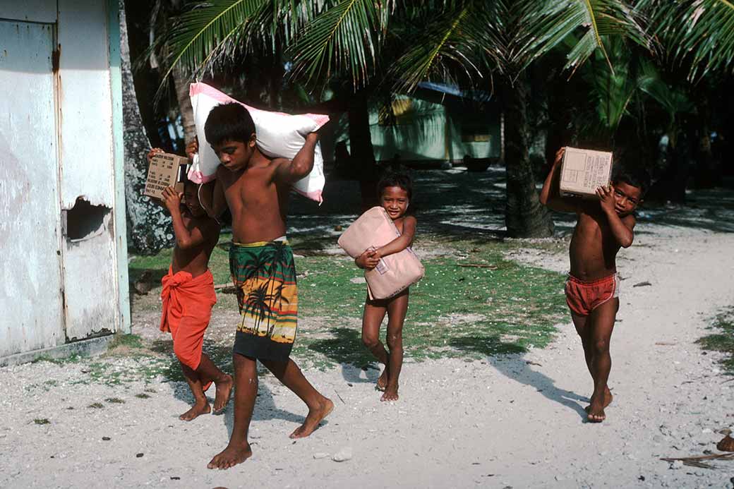 Boys carrying supplies, Onari