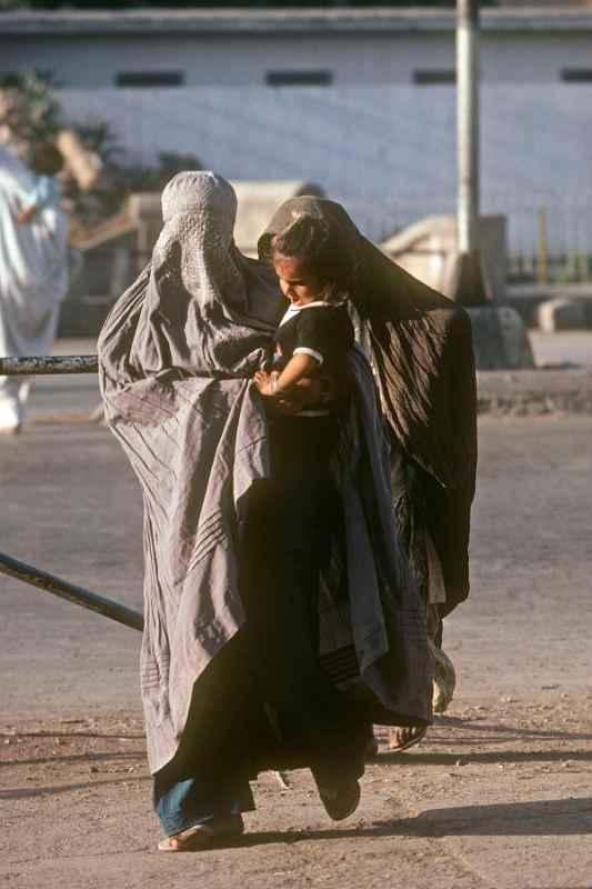 Woman in burqa and child