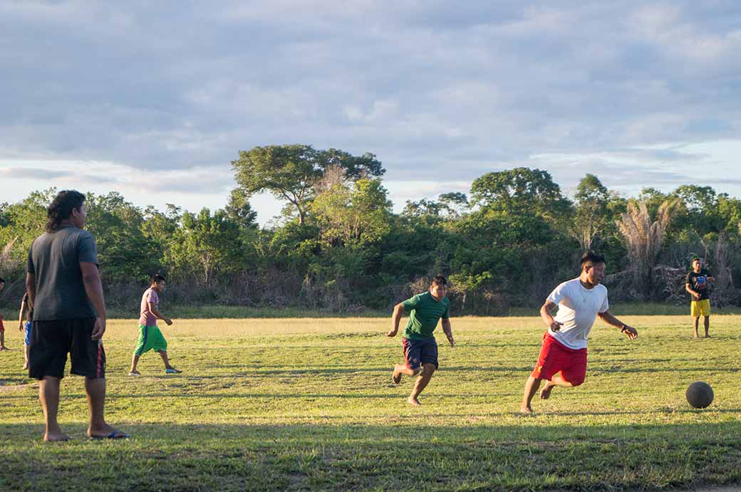 Men playing football, Palumeu