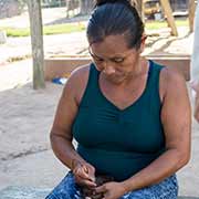 Tiriyó woman making necklace